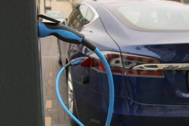 Elektrikli araba ve şarj istasyonunda.