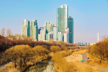 güneşli bir günde arka planda binalar ile akarsu