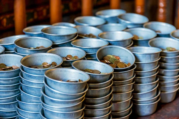 Coins in donation bowls for a buddhist temple — Stock Photo, Image