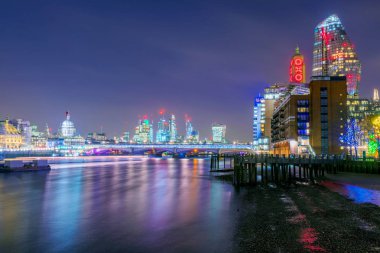 Night view of City buildings along the river Thames clipart