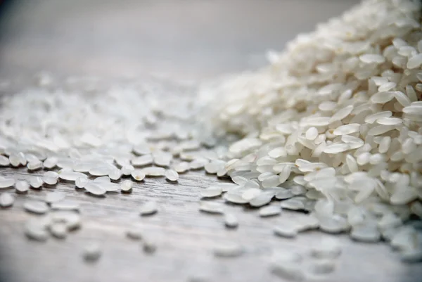 Grãos de arroz saborosos brancos na mesa — Fotografia de Stock