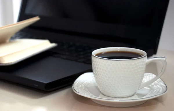 Bloc-notes vierge sur ordinateur portable et tasse de café . Image En Vente