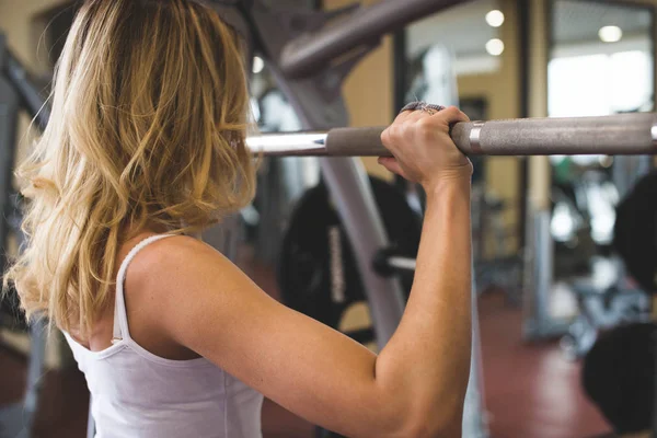 Het meisje liften de gewicht-staaf in de sportschool — Stockfoto