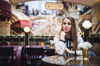 bir kafede otururken sıcak kahve içme kız