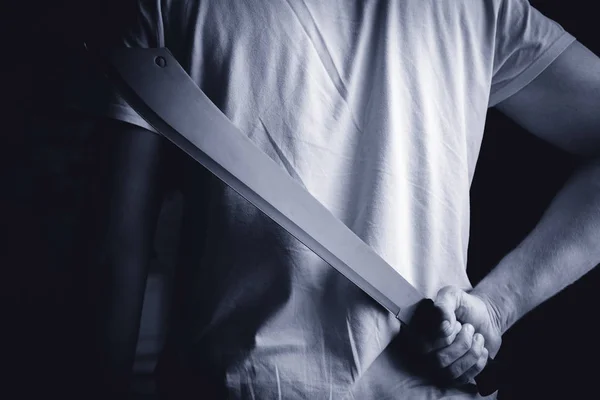 A man holds a machete in hand behind — Stock Photo, Image