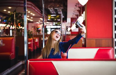 Kafede oturan selfie alarak pencerenin arkasında kadın