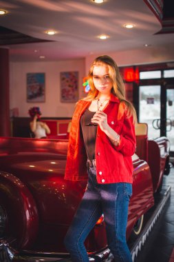 Güzel esmer, genç bir kadın elbise giyiyor ve sokakta yürüyor.