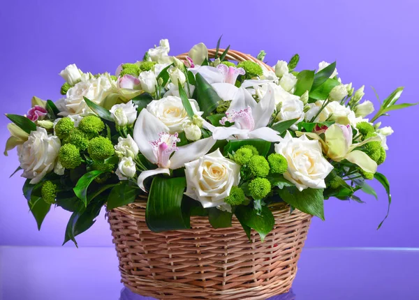 Hasır sepetteki çiçek buketini kapat. Beyaz, karanfil, gül, orkide, anunkulus.