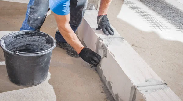 Bricklayer laying blocks. the Builder applies cement for fixing