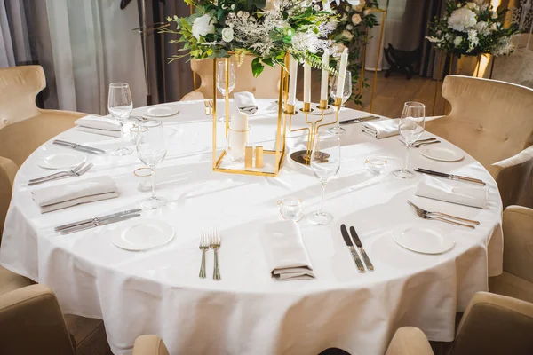 Glasses, flower fork, knife served for dinner in restaurant with cozy interior — Stock Photo, Image