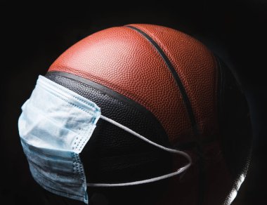 Hastalığı yen. Koruyucu maskeli top oynayan basketbolcu. Ateş, baş ağrısı, öksürük gibi zatürree solunum semptomlarının önlenmesi. Çin koronavirüsü. Sağlık, tıp, spor konsepti.