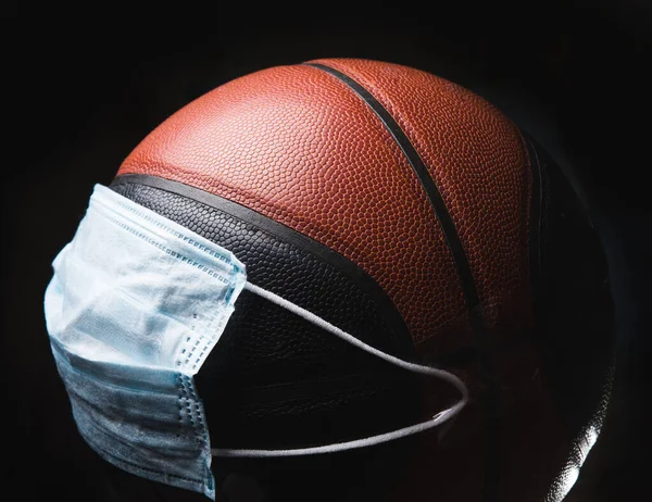 Beat the disease. Basketball player with ball in protective mask. Prevention of pneumonia respiratory symptoms such as fever, headache, cough. Chinese coronavirus. Healthcare, medicine, sport concept.