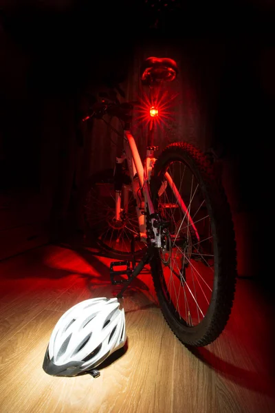 Bisiklet kaskı bisiklet tekerleğinin önünde, bisiklet parkı tarafında.