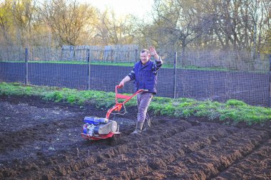 Adam profesyonel bahçıvan bahçesinde yeşil çimlerle tarla sürüyor.