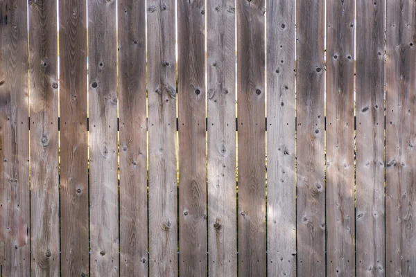 Primer plano de una cerca de madera envejecida con agujeros de nudo, para el fondo . —  Fotos de Stock