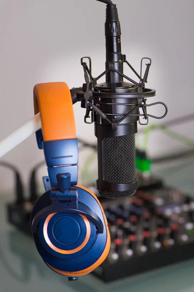 Micrófono de condensador con auriculares en el estudio, detrás de la batidora preparándose para grabar en vivo . Imagen de stock