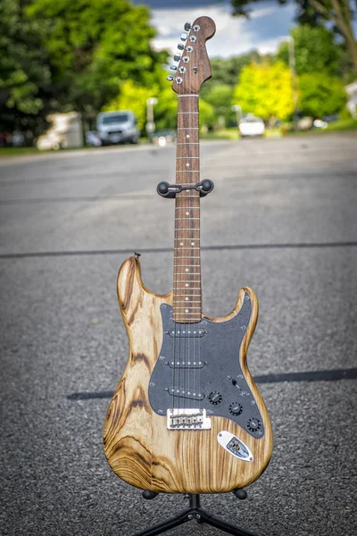 Fender stratocaster electric guitar, shot out the street, Natural wood guitar, Walnut neck.
