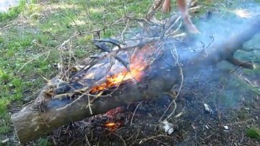 Bir adam çıplak ayaklı su birikintisi - 15s kıyıda bir ateş yakmak