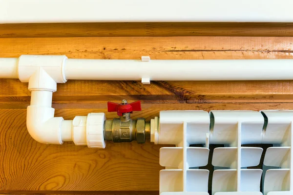 Heating radiator and polypropylene pipes  in a wooden house — Stock Photo, Image