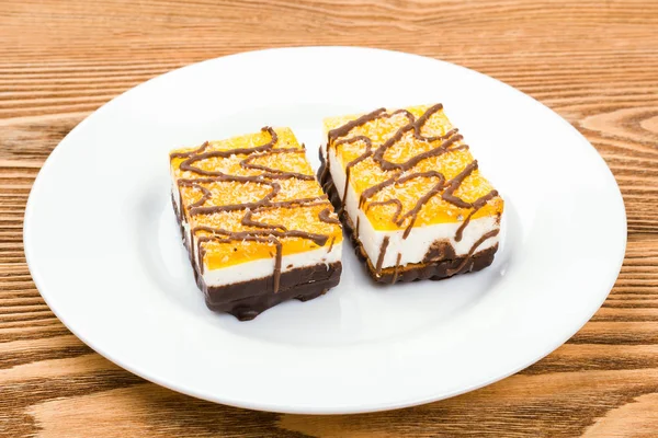 Dos Pasteles Chocolate Plato Blanco Sobre Fondo Madera —  Fotos de Stock