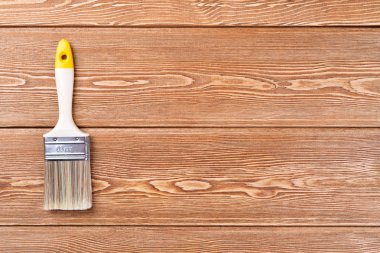 Ahşap arka plan üzerinde plastik saplı düz boya fırçası 