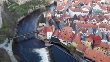 Czech kasabası Cesky Krumlov 'un tarihi evlerinin insansız hava aracı görüntüsü. Unesco listesindeki şehir. Nehir manzarası ve kırmızı kiremitli çatılar. Çek Cumhuriyeti, 4K