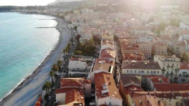 Sahil şeridinin, plajın ve kırmızı kiremitli çatıların havadan görüntüsü. Menton, Cote d 'azur, Fransız Rivierası. 4K