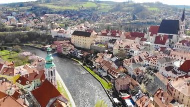 Cesky Krumlov 'un insansız hava aracının panoramik görüntüsü. Nehir manzarası ve güneşli bir günde kırmızı kiremitli çatıları olan antik şehir