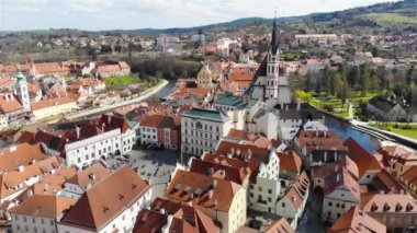 Çek Cumhuriyeti 'nin Cesky Krumlov kentinin sinematik hava manzarası, kırmızı kiremitli çatıları ve Saint Vitus Katedrali, 4K
