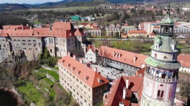 Güneşli bir günde Çek Cumhuriyeti 'nde kırmızı kiremitli çatıları olan ünlü Cesky Krumlov Kalesi' nin insansız hava aracı görüntüsü, 4K