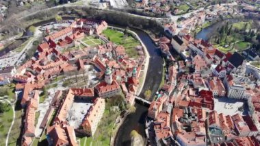 Güneşli yaz gününde ünlü antik Czech kasabası Cesky Krumlov 'un insansız hava aracı görüntüsü. Kırmızı kiremitli çatıların, meydanların, nehrin, şatonun ve kale kulesinin üstünden bak. 4K 'da Çek Cumhuriyeti