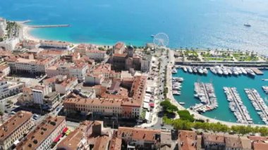 Güneşli bir yaz gününde deniz kıyısında güzel bir Fransız şehri. Deniz manzarası, liman, yatlar, kiliseler ve kırmızı kiremitli çatıları olan evler. Hava görüntüsü. Saint Raphael, Fransa 4K 'da.