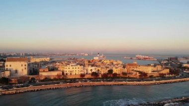 Gün doğumunda deniz kenarında bir İtalyan şehrinin hava görüntüsü. Bari, Puglia, İtalya. 4K içinde hava görüntüsü