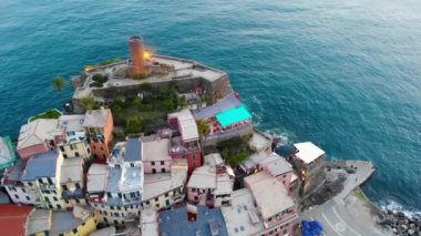Denizle çevrili kayalıklardaki güzel bir İtalyan köyünün hava görüntüsü. Vernazza, Cinque Terre, İtalya 'ya bakıyorum. 4K