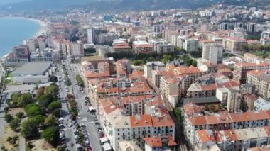 Güzel İtalyan sahil kasabasında İHA uçuşu. Sokakta trafiğin olduğu bir kasaba. Hava görüntüsü. Savona, Liguria, İtalya