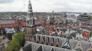 Hollanda, Amsterdam 'ın hava aracı görüntüsü. Eski merkez bölgedeki kilise ve mimari binaların manzarası. 4K