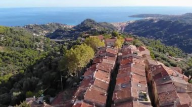 Güneşli bir günde Fransız Rivierası 'ndaki güzel antik Castellar köyünün insansız hava aracı görüntüsü. Arka planda Akdeniz. 4K 60fps