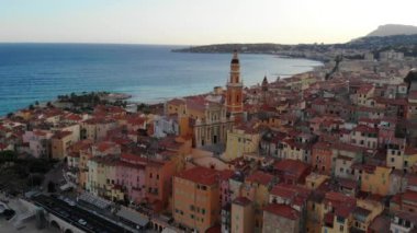 Kilisenin ve denizin arka planındaki renkli evlerin insansız hava aracı görüntüsü. Menton, Cote d 'azur, Fransız Rivierası. Yukarıdan görüntüle