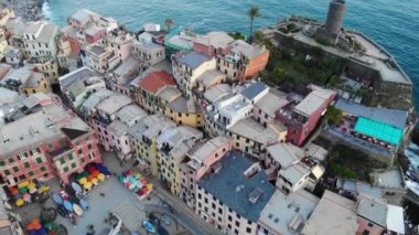 Yukarıdan Vernazza. Kayalıklardaki güzel İtalyan köyü denizle çevrili. Kalenin havadan görünüşü, evlerin çatıları, kilise ve tekneler. Cinque Terre Ulusal Parkı, Liguria, İtalya. 4K