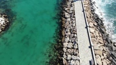 Güneşli bir yaz gününde deniz üzerindeki hava aracı ve dalgakıran manzarası. Ayia Napa, Kıbrıs, 4K