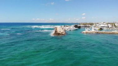 Güneşli bir yaz gününde deniz üzerinde dalgalı bir deniz boyunca insansız hava aracı uçuşu. Yukarıdan bak. Ayia Napa, Kıbrıs, 4K