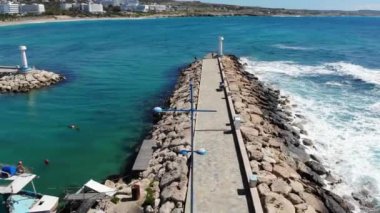 Güneşli bir yaz gününde deniz üzerinde dalgalı bir deniz boyunca insansız hava aracı uçuşu. Yukarıdan bak. Ayia Napa, Kıbrıs, 4K