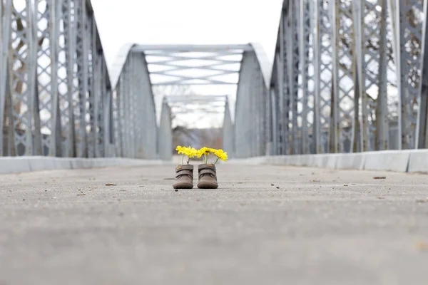 Bir demir köprü üzerinde Sarı çiçekli Bebek Patiği