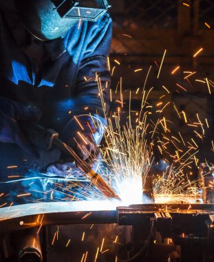 Koruyucu maskeli, kaynak yapan bir işçi.