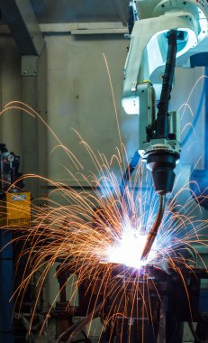 Robotlar araba fabrikasında kaynak yapıyor. 