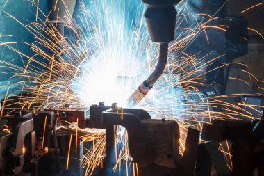 Robotlar araba fabrikasında kaynak yapıyor.