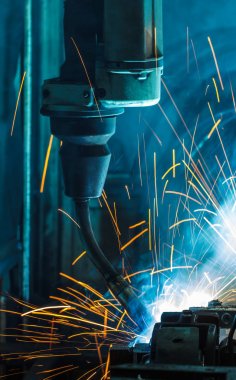 Robotlar araba fabrikasında kaynak yapıyor.