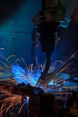 Robotlar araba fabrikasında kaynak yapıyor.