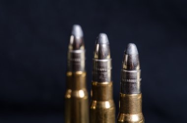 Bir bardak yansıma ile koyu mavi bir arka plan üzerinde Mühimmat. Yakından kapatın. Silah. Mermi 