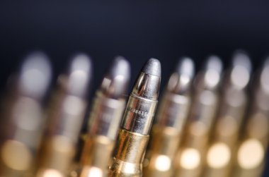 Bir bardak yansıma ile koyu mavi bir arka plan üzerinde Mühimmat. Yakından kapatın. Silah. Mermi 